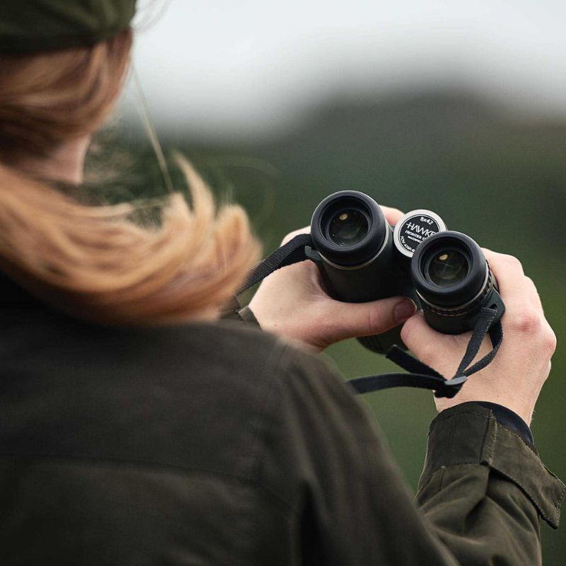 A female explorer holding the Hawke Frontier APO 8x42 Binoculars